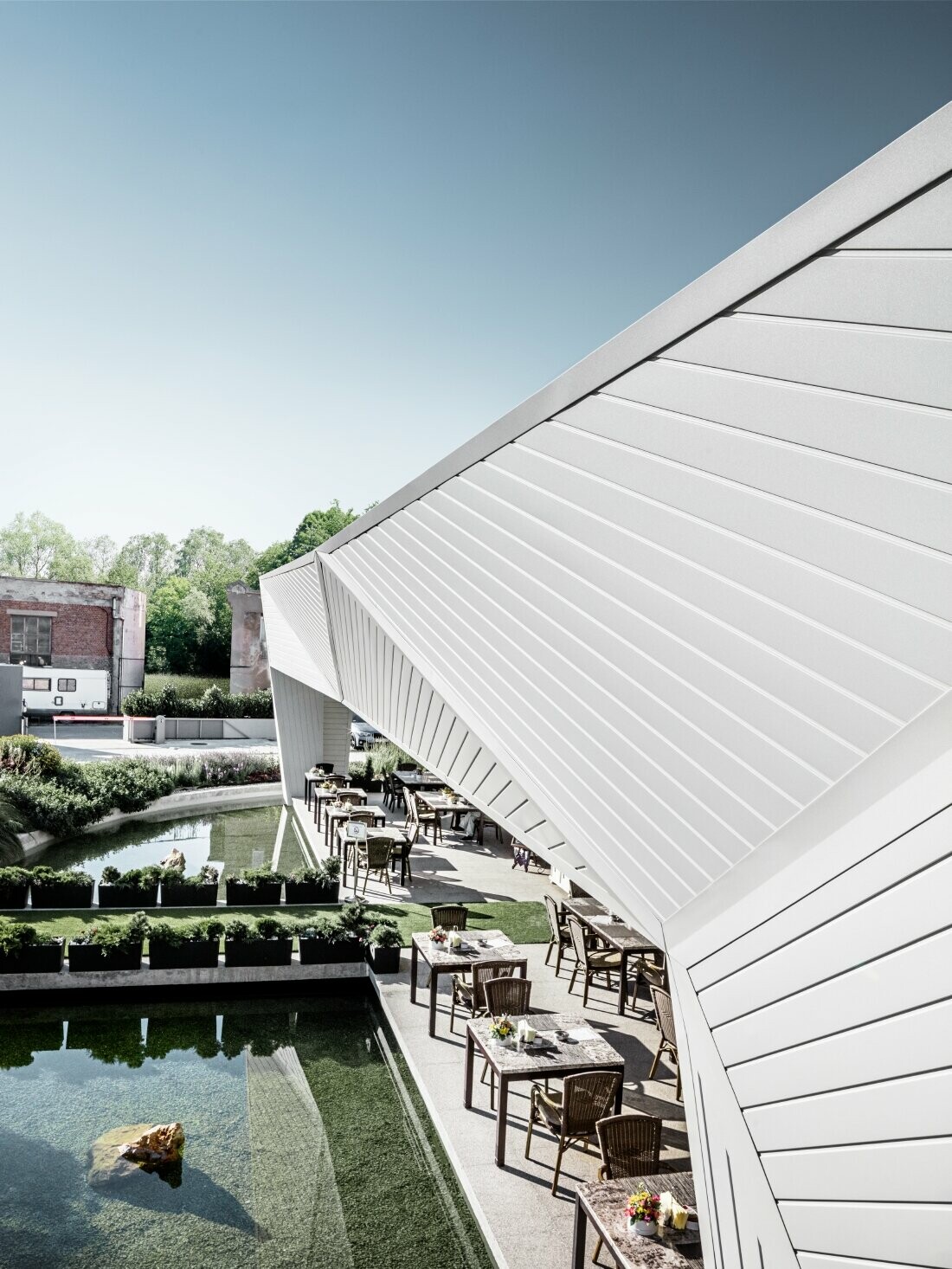 Outdoor dining area of the Mimama restaurant in Budapest with the 3D façade clad in the PREFA sidings in Prefa white.