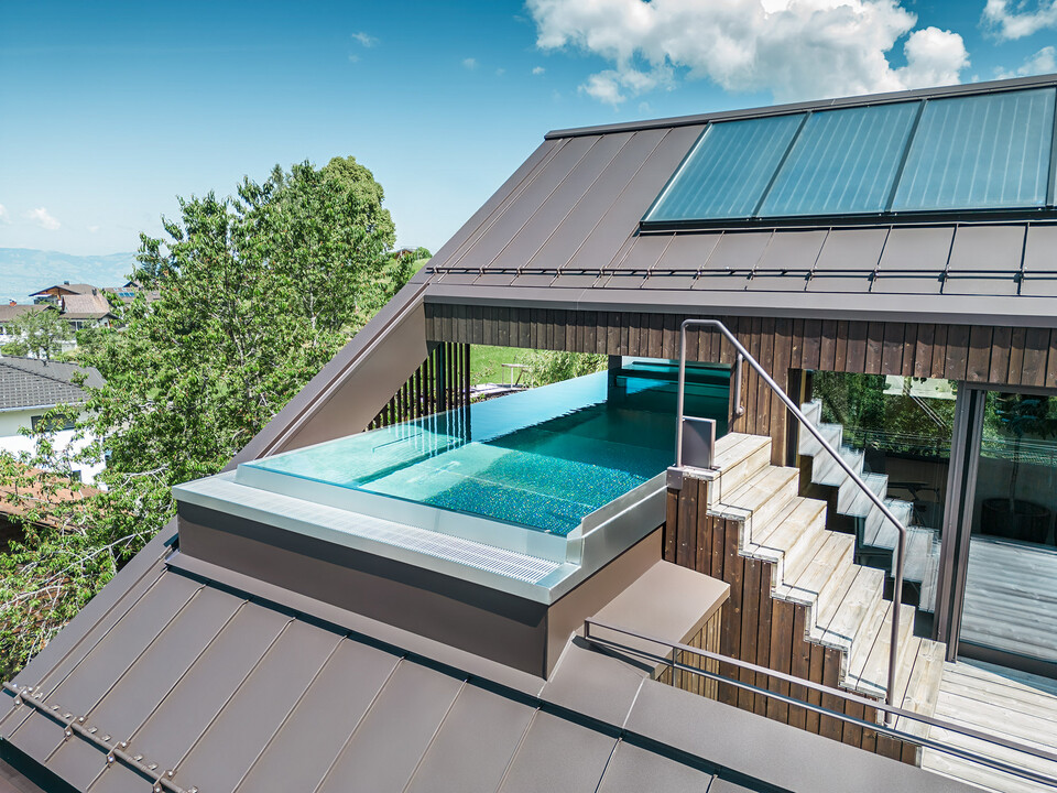 Section of the pool embedded in the sloping roof of the multi-family house Matino in Übersaxen.