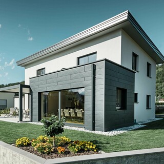 Detached house with extension, the extension is clad with a PREFA aluminium façade, the flat roof is drained using the PREFA parapet outlet connector and PREFA downpipe in P.10 anthracite,