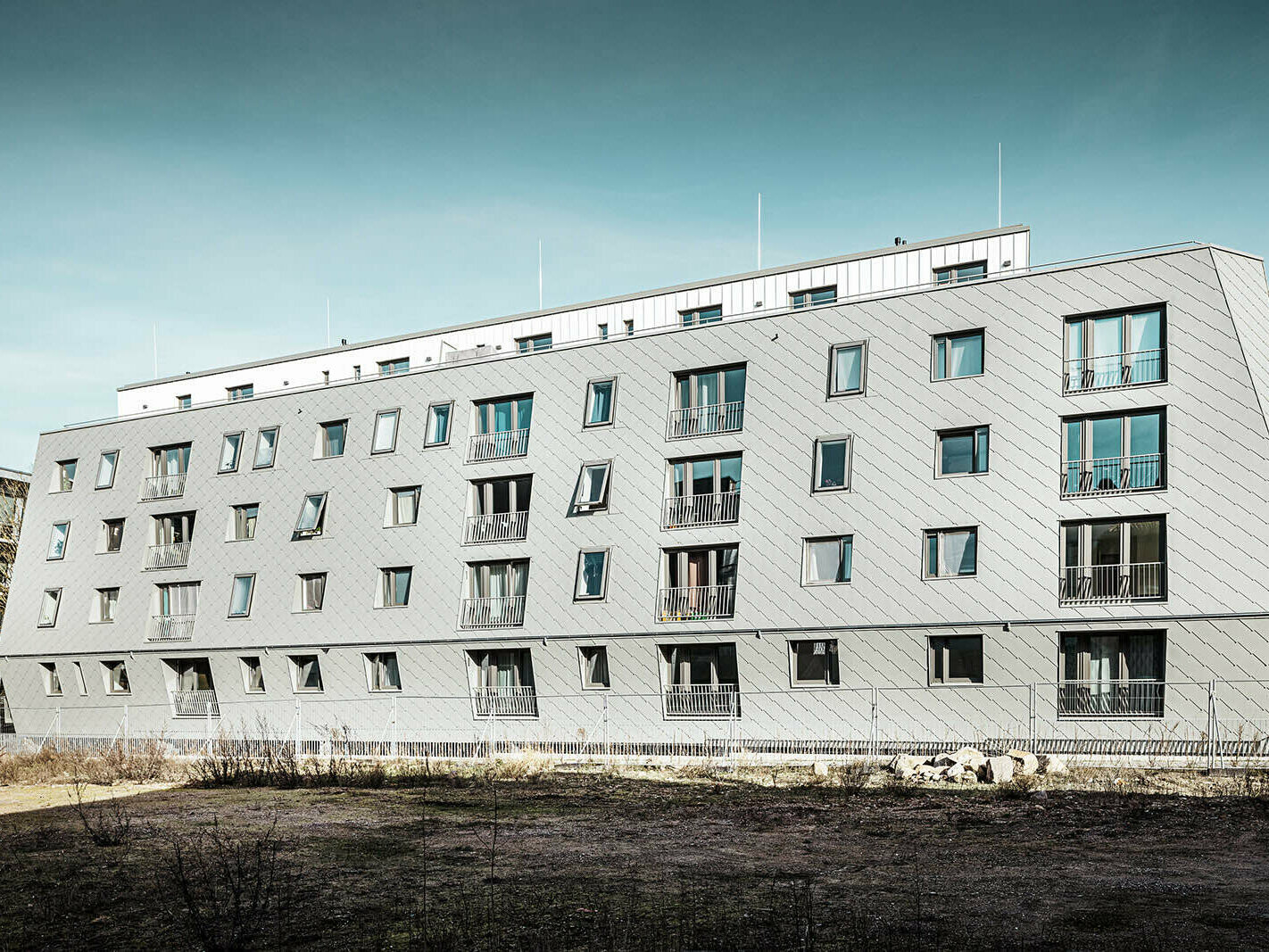 The picture shows the house in Harburg's inland harbour by day, which was roofed with PREFA rhomboid façade tiles 44x44 and Prefalz.