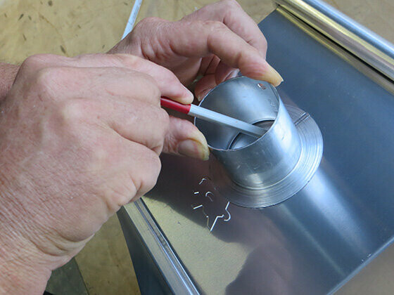 Preparation for creating an emergency overflow in a PREFA leader head — Step 1: Position and mark.