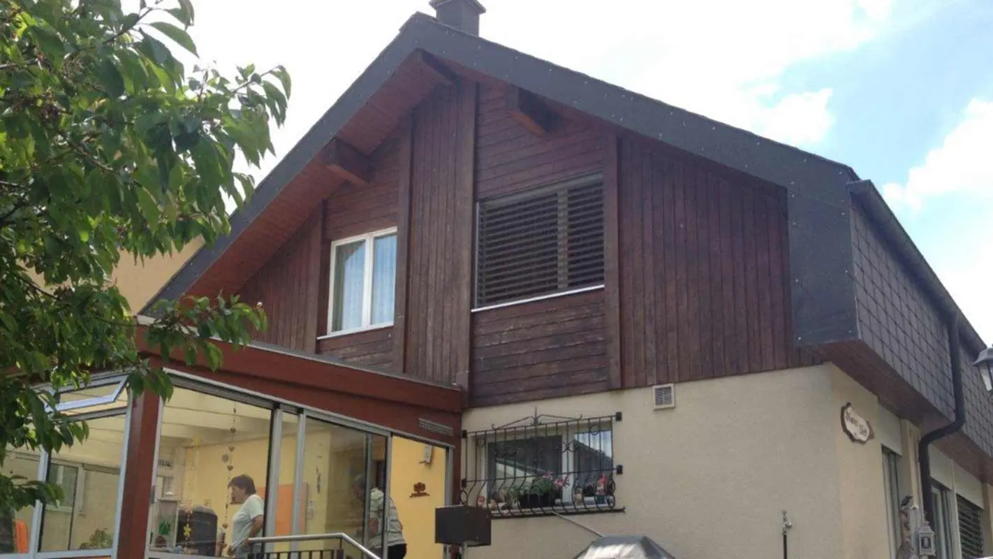 House before renovation of façade with wood-effect PREFA sidings; gable is clad with weathered wood
