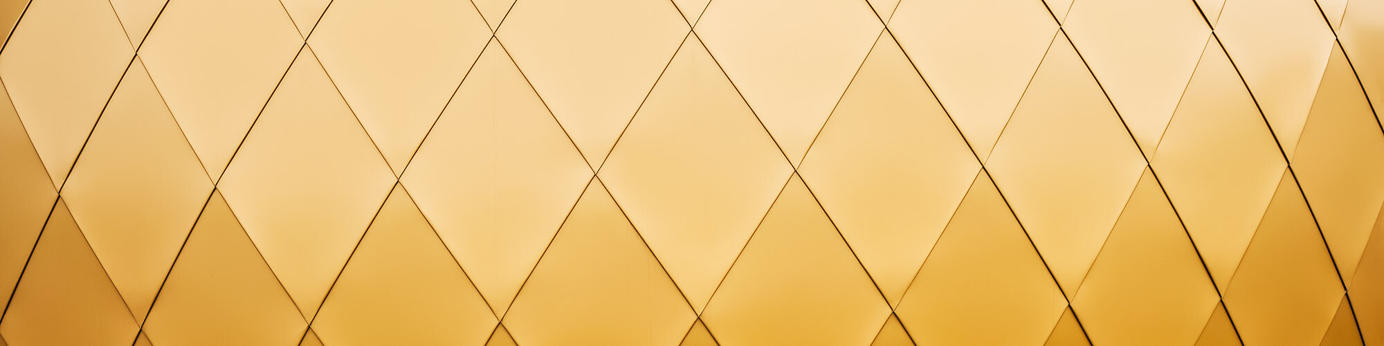 A close-up of the gold shimmering PREFA façade.