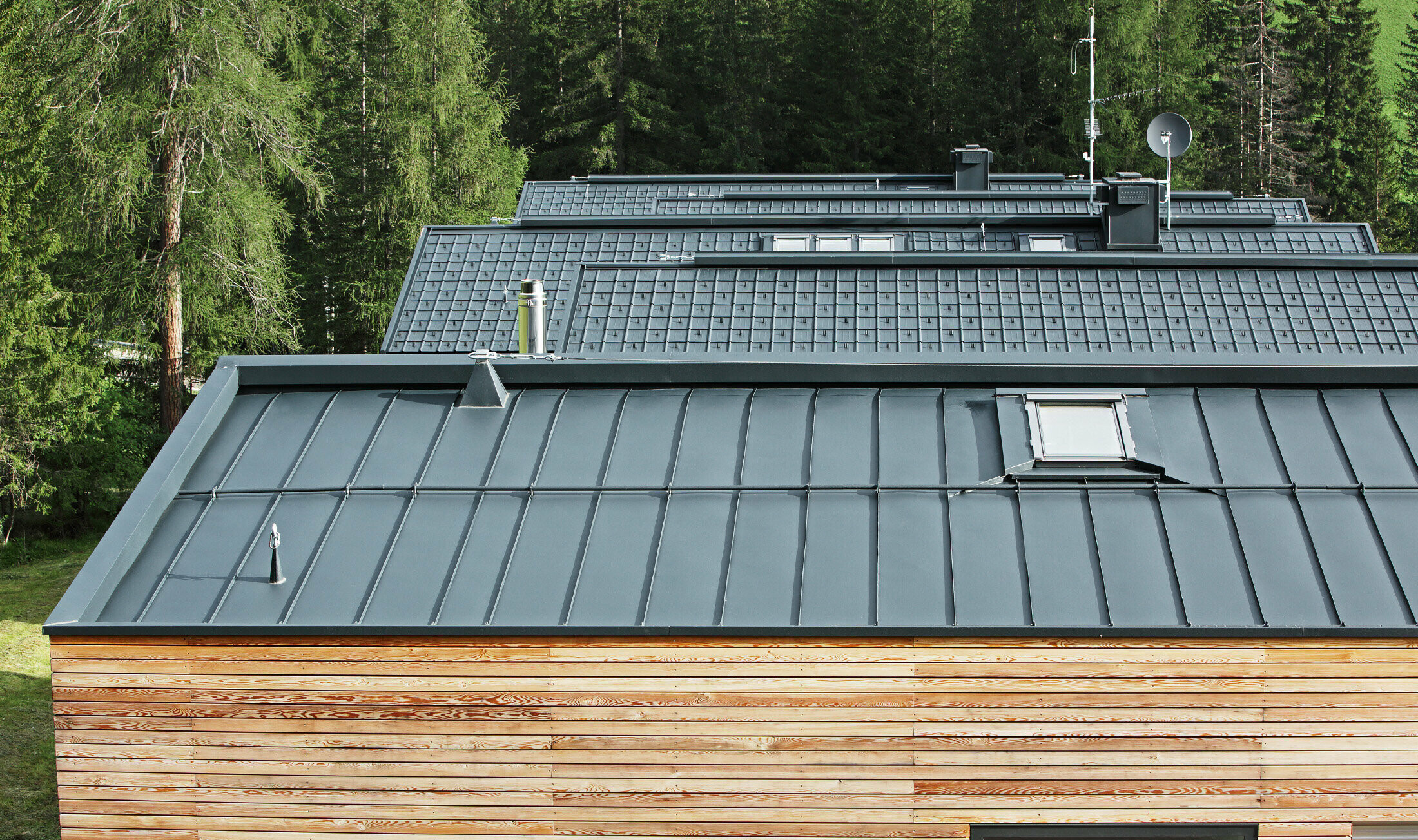 Residential area with horizontal wooden façade and PREFALZ and tiled roof in P.10 anthracite