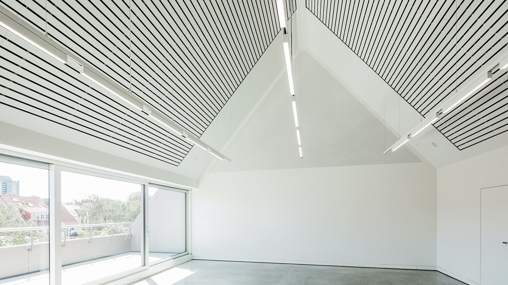 A view of the all-white interior of the art museum, with lighting on the ceiling.