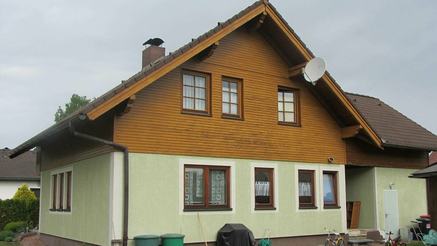 Before renovation of gable façade with PREFA sidings, weathered wooden façade