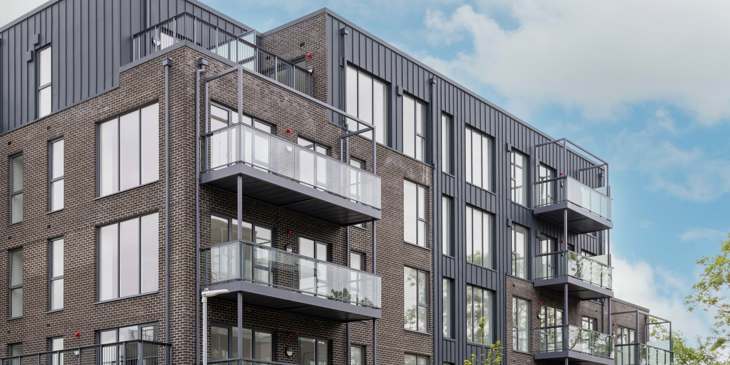 A bird's eye view of the Balroy Hall residential complex, Carpenterstown, Dublin. PREFALZ façade cladding in P.10 anthracite and classic brick architecture. Sustainable aluminium on an 800 m² façade area for urban design and durability.