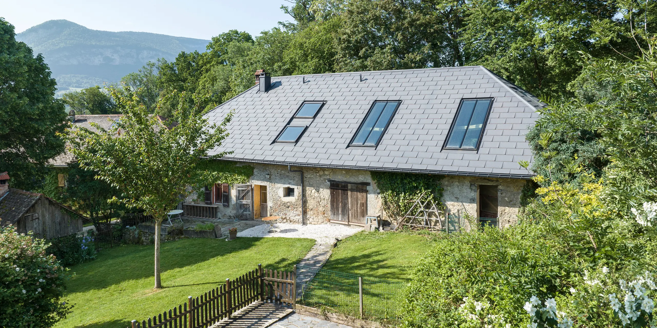 [Translate to English:] PREFA Dachplatte R.16 in P.10 Dunkelgrau auf dem Dach eines alten Bauernhofs in Héry-sur-Alby (Frankreich)