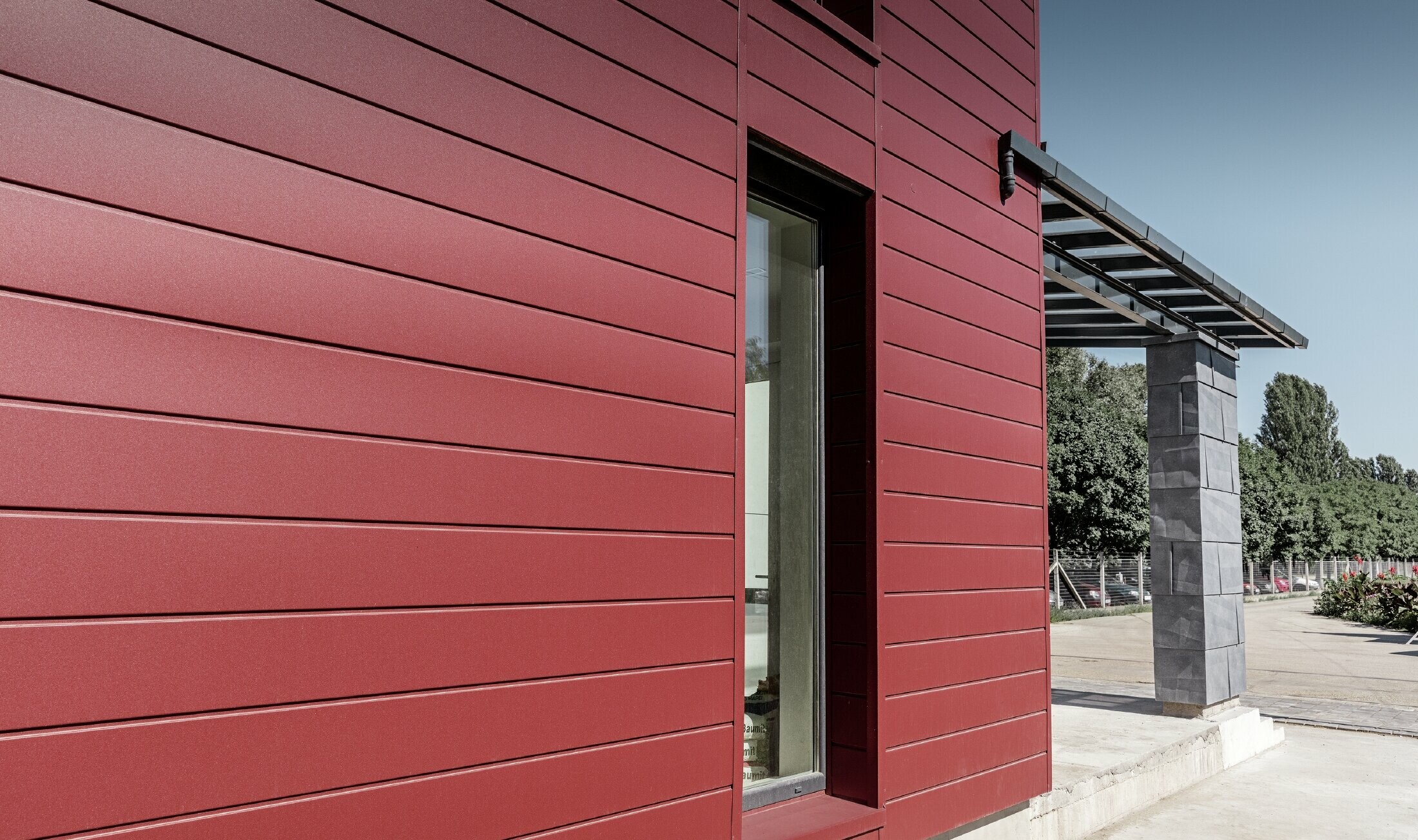 Modern office building with a divided façade in red, stone grey and white, and sidings, FX.12 façade panels and aluminium composite panels made by PREFA Aluminiumprodukte GmbH