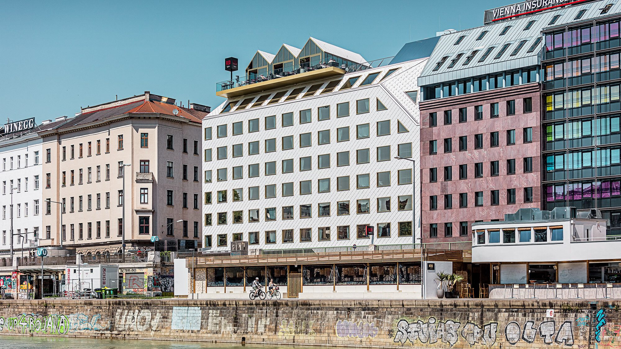 The hotel and its built environment from a side perspective, the Danube Canal extending right before it.