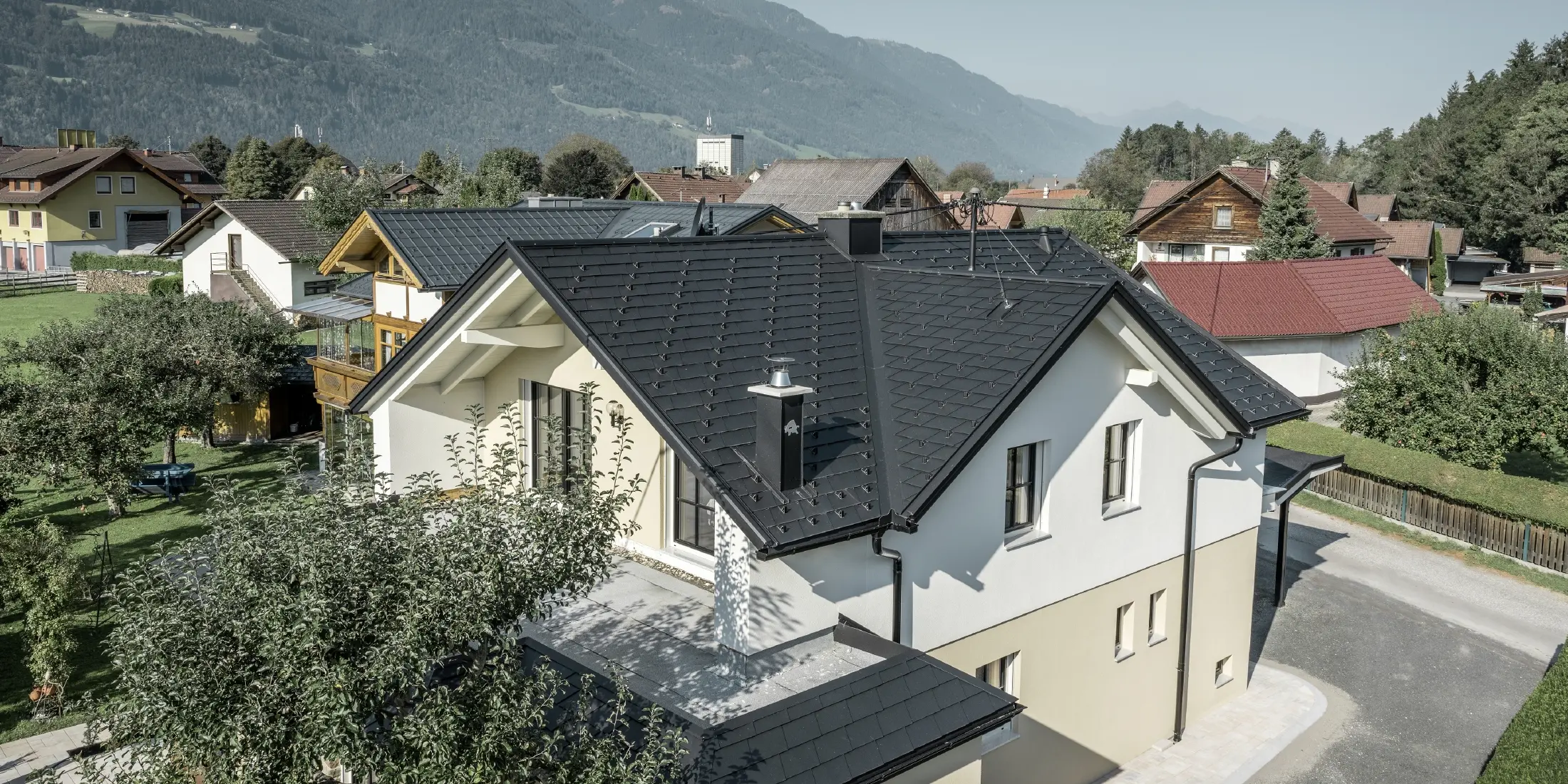 Traditional detached house with gabled roof and large dormer window, newly renovated. The roof is covered with black shingles from PREFA.