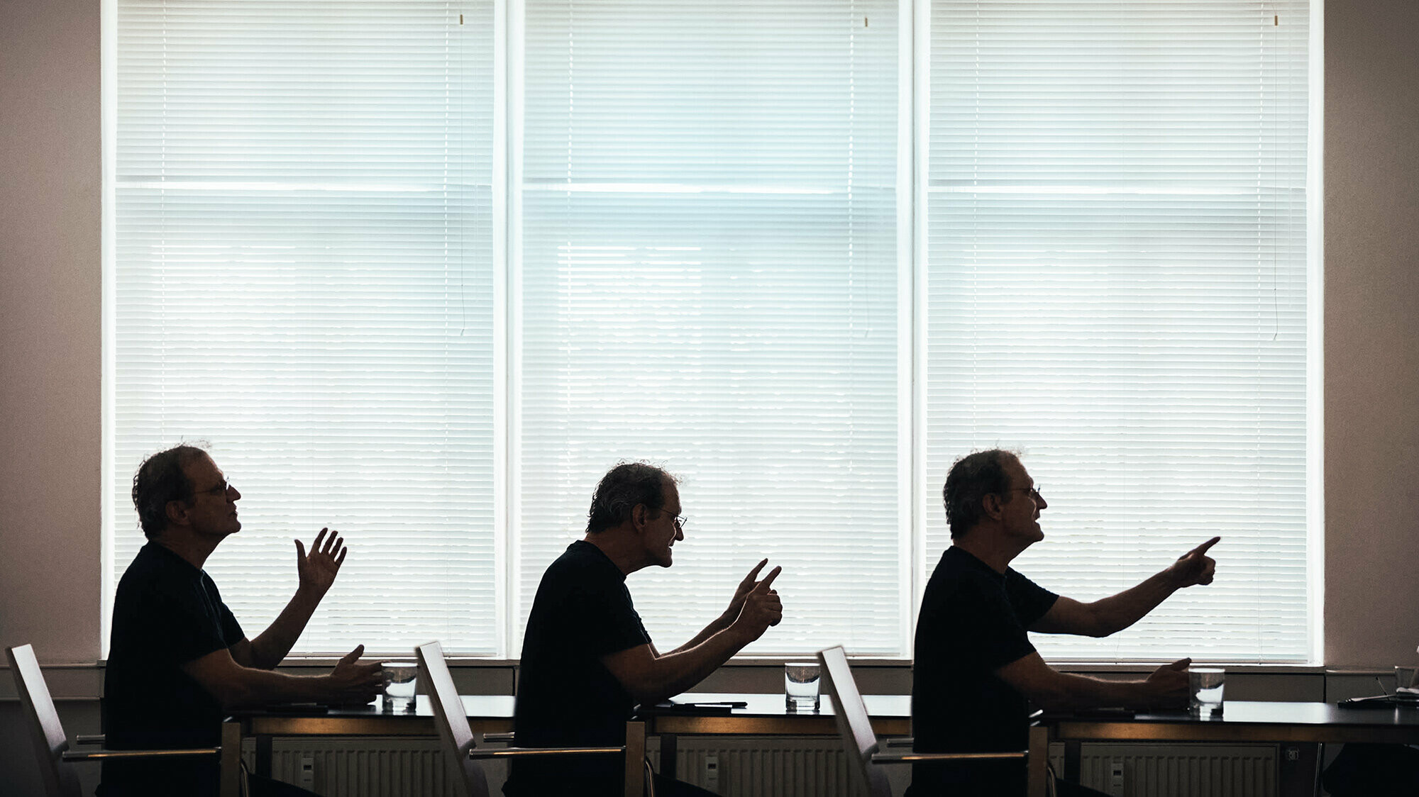 Three profile views of the architect Anton Mariacher looking to the right with different gestures.