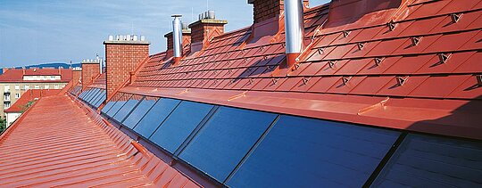 Detailed image of PREFA roof shingles in brick red, including snow guards, at Hugo Breitner Court.