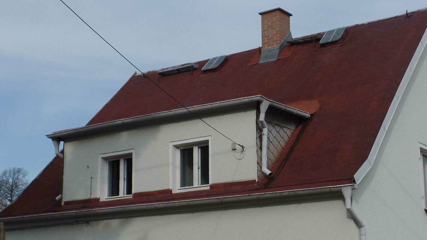 Property with eyebrow dormer renovated with PREFA shingles