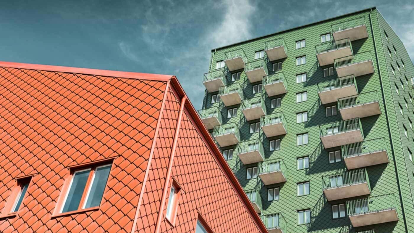 Swedish residential buildings with balconies and PREFA rhomboid wall tiles in green and brick red.