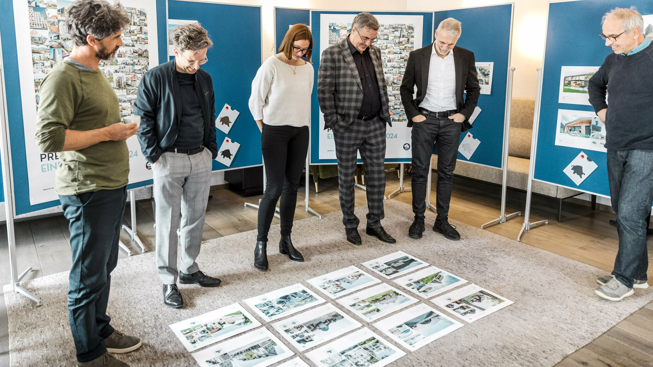 The participants of the PREFARENZEN dialogue discussing the projects, the project sheets are lying on the floor. 