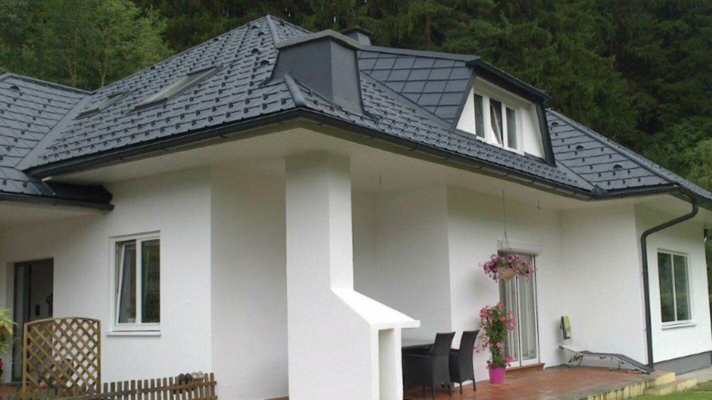 Detached house with a hipped roof before roof renovation with PREFA roof tiles including trapezoidal dormer