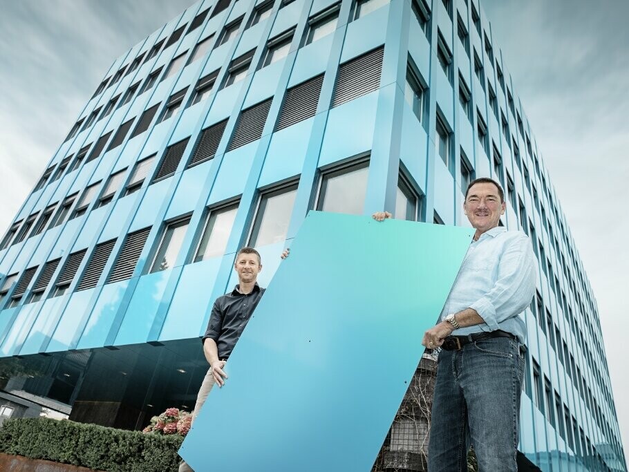 Stefan Wildi (head of PREFA Switzerland) and building manager Christian Rettenbacher in front of the Wielandhaus in Arauch, Switzerland. THe building is covered in PREFABOND aluminium composite panels in a bespoke colour green-blue.