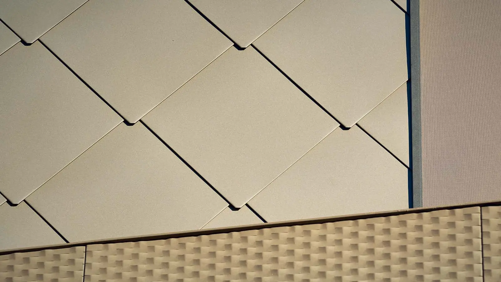 The picture shows a close-up of PREFA rhomboid façade panels 44 x 44 with the special coating P.10 Bronze.