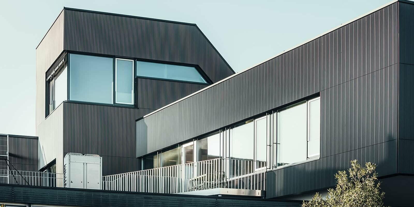 Lateral view of the Amann coffe building on a sunny day. Serrated profile in the colour black was used, to protect the building.