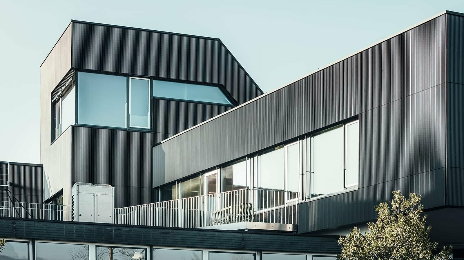 Lateral view of the Amann coffe building on a sunny day. Serrated profile in the colour black was used, to protect the building.