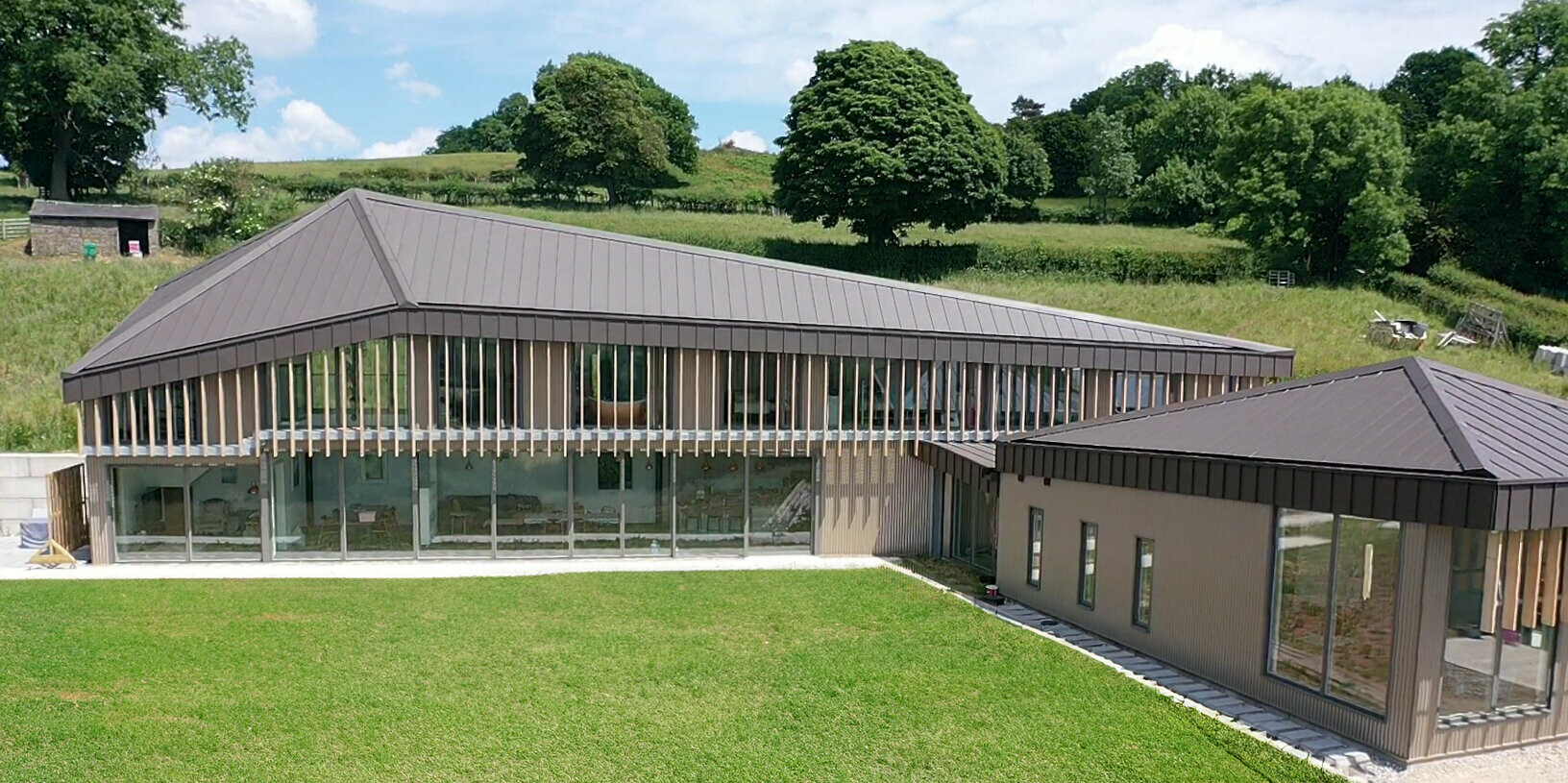 Side perspective on Derbyshire longhouse with PREFALZ roof in P.10 Brown