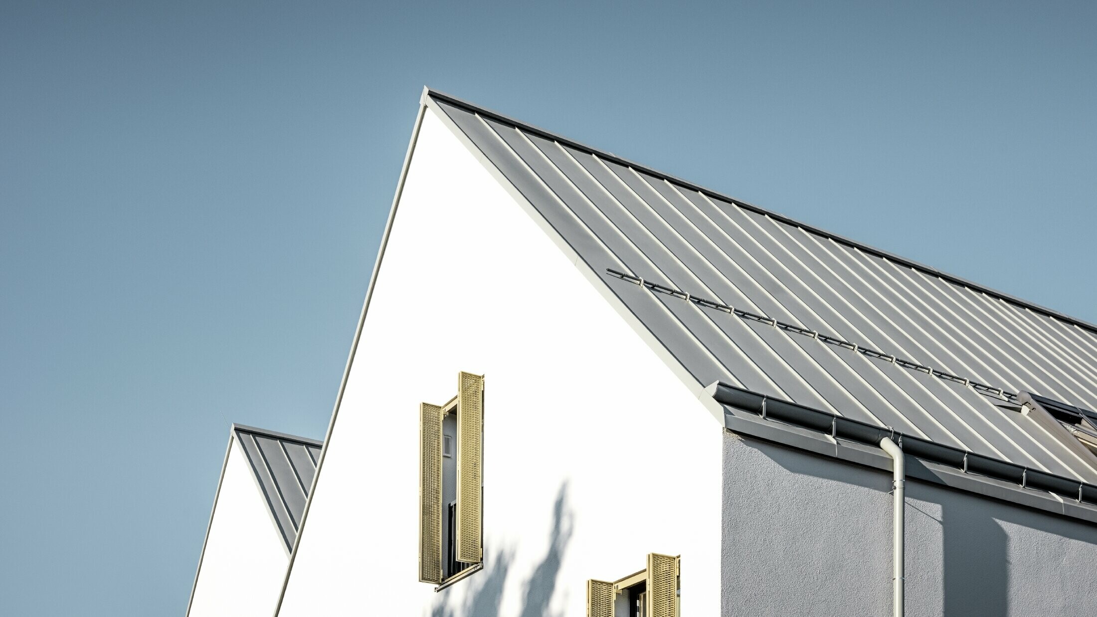 Gable roof without eaves, covered with PREFALZ in P.10 zinc grey with PREFA on-roof gutter