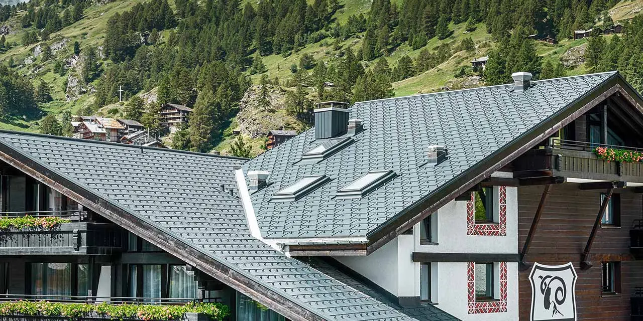 Hotel Alpenhof in Zermatt (Switzerland) with the Matterhorn mountain in the background, balconies, dark wooden façades and a PREFA aluminium roof in anthracite