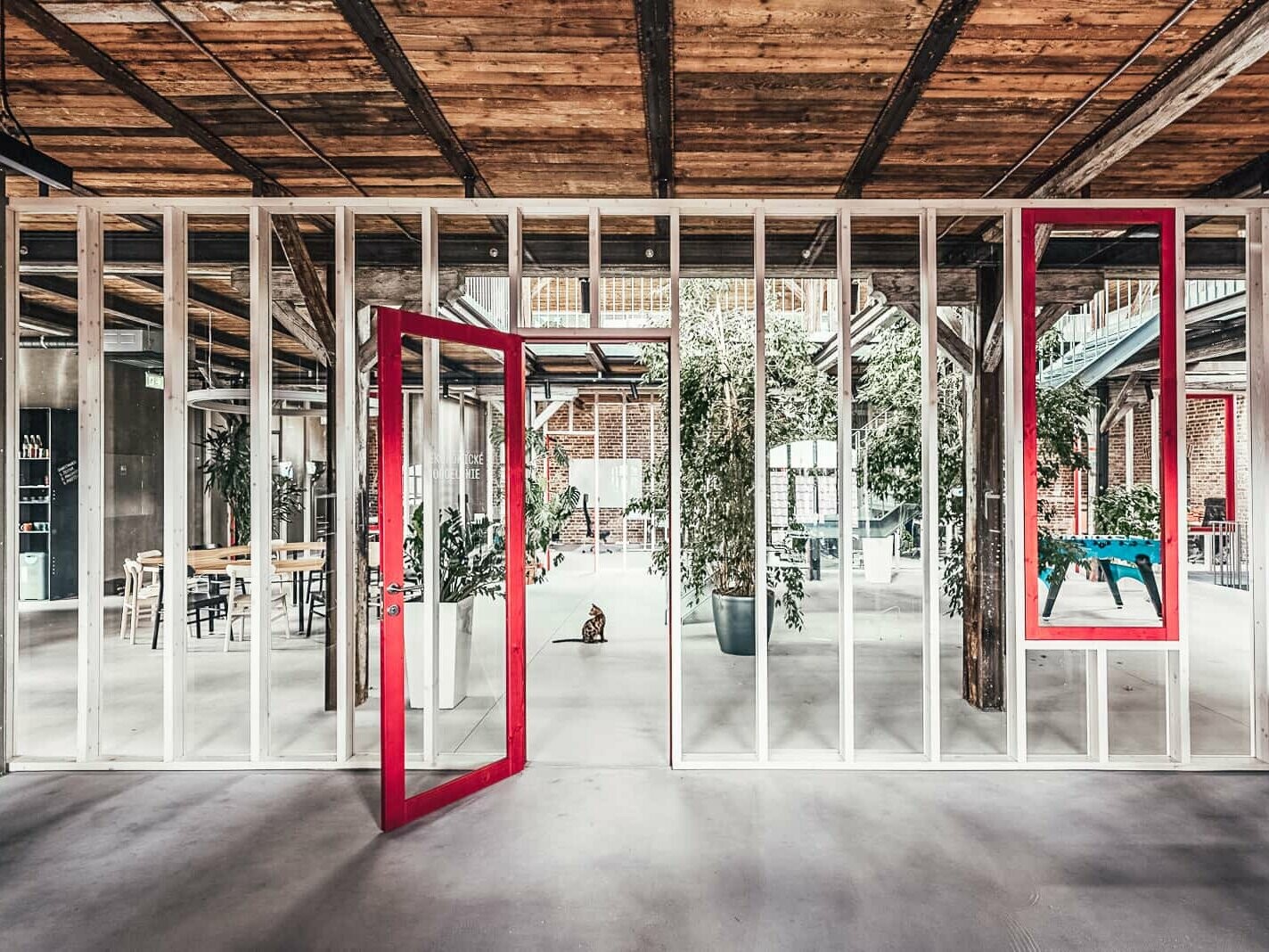 A shot from the interior of the enamel factory. The ceiling is made of wood. With red frame accents, the glass front becomes a real eye-catcher.