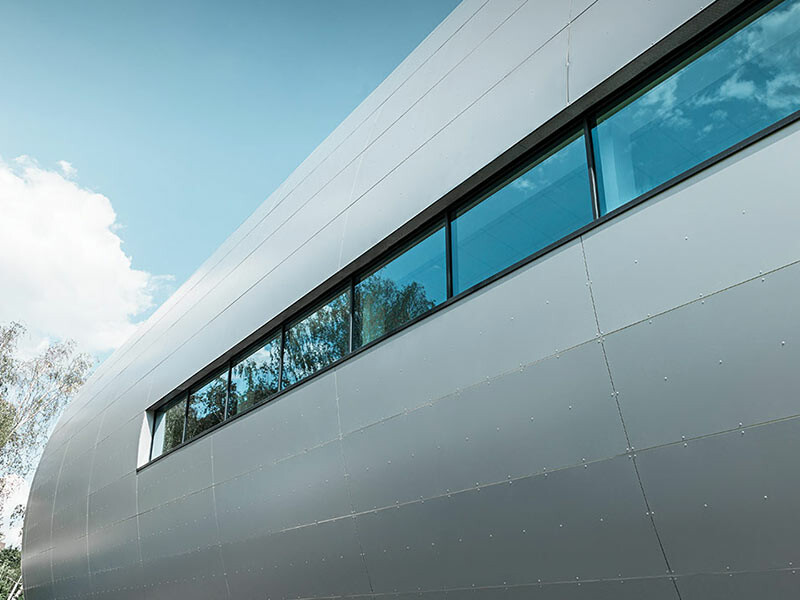 Side view of the tube at the Allianz Stadium in Vienna for SK Rapid. The tube is clad in aluminium composite tiles in metallic silver.