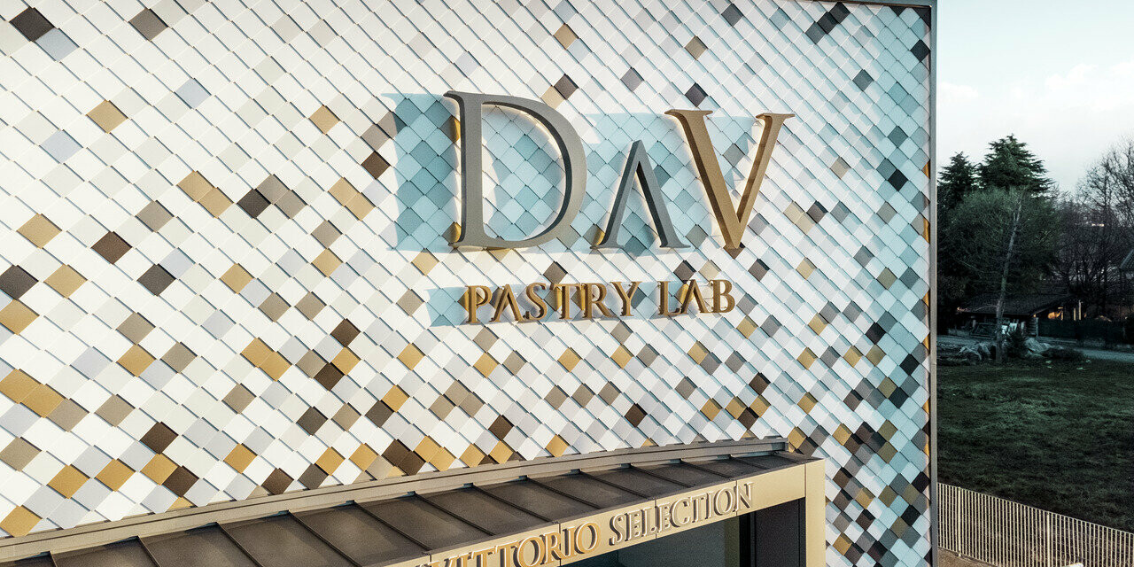 DAV Pastry Lab company building in Bergamo with a speckled rhomboid tile façade in the colours P.10 brown, bronze, P.10 dark grey, maya gold, plain aluminium, P.10 PREFA white and P.10 pure white 