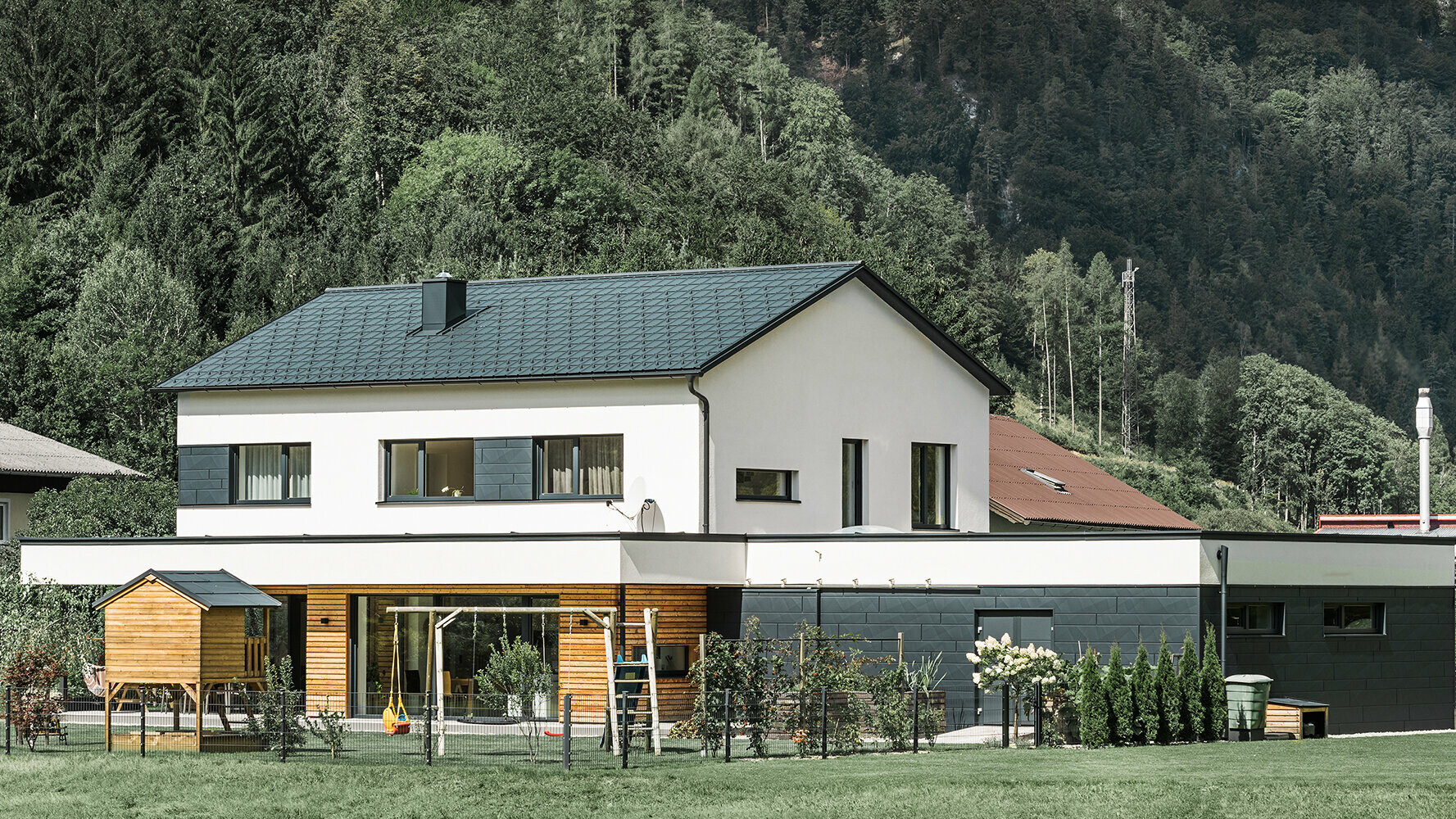 Detached house new building with larch wood façade in combination with  PREFA Siding.X in anthracite.