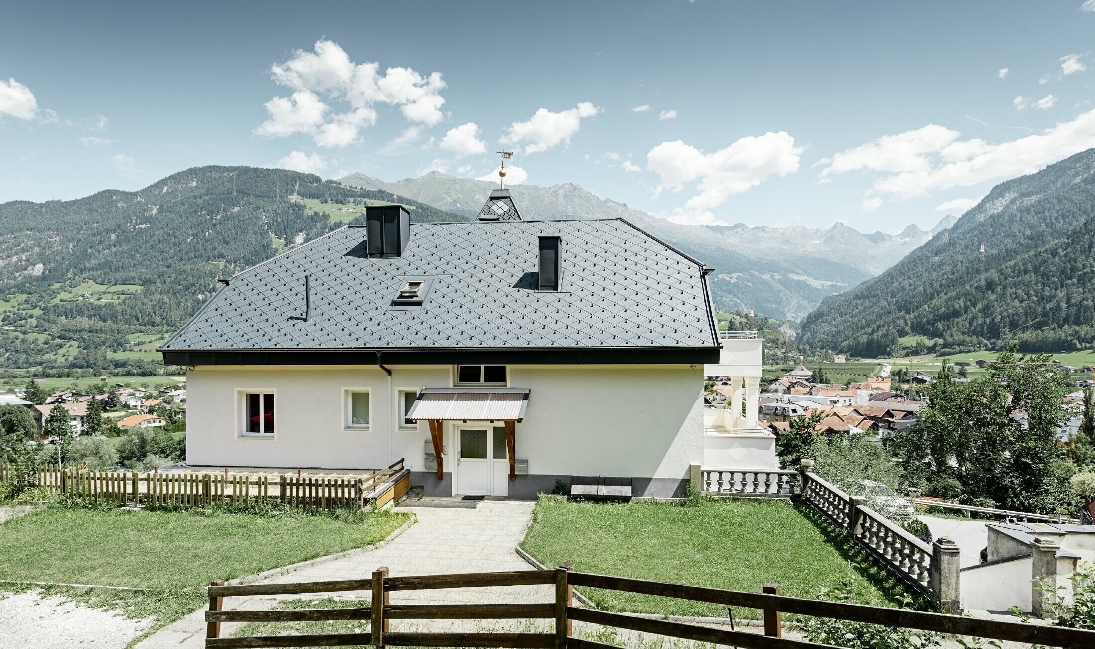 Rock cabin with a tower and an aluminium roof in anthracite with a Pizzeria on the ground floor