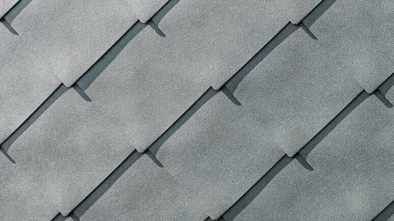 Detailed image of the PREFA aluminium rhomboid façade tiles 44 × 44 in P.10 stone grey