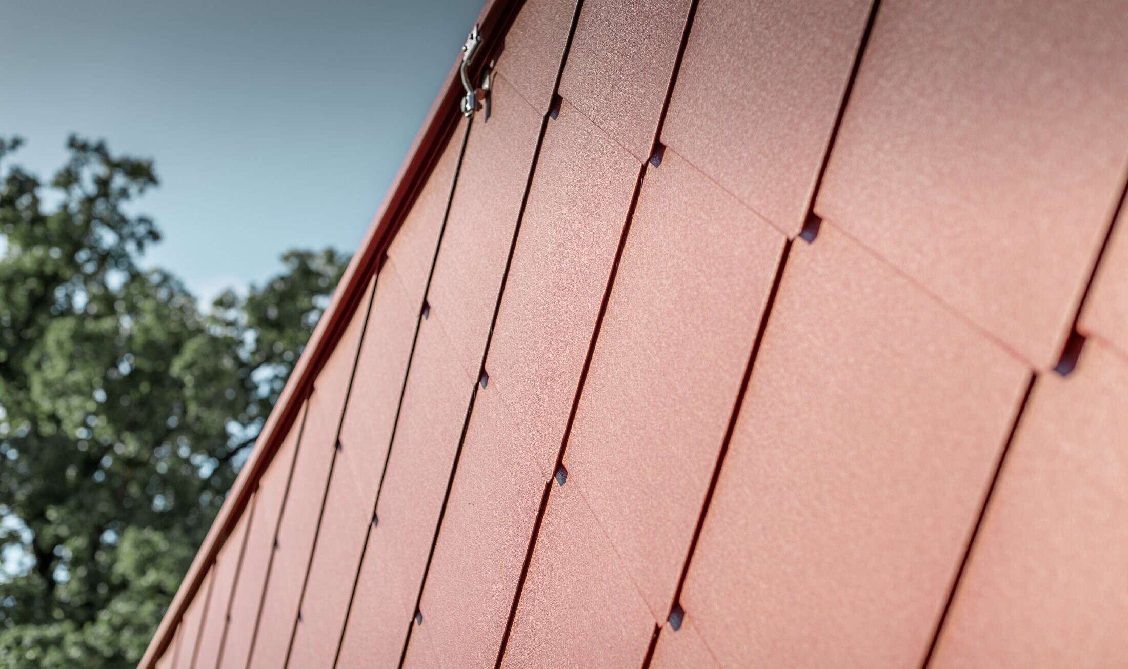 Close up of the PREFA 44 x 44 rhomboid tile in oxide red, taken at the Kerzenwelt candle store in Schlägl;