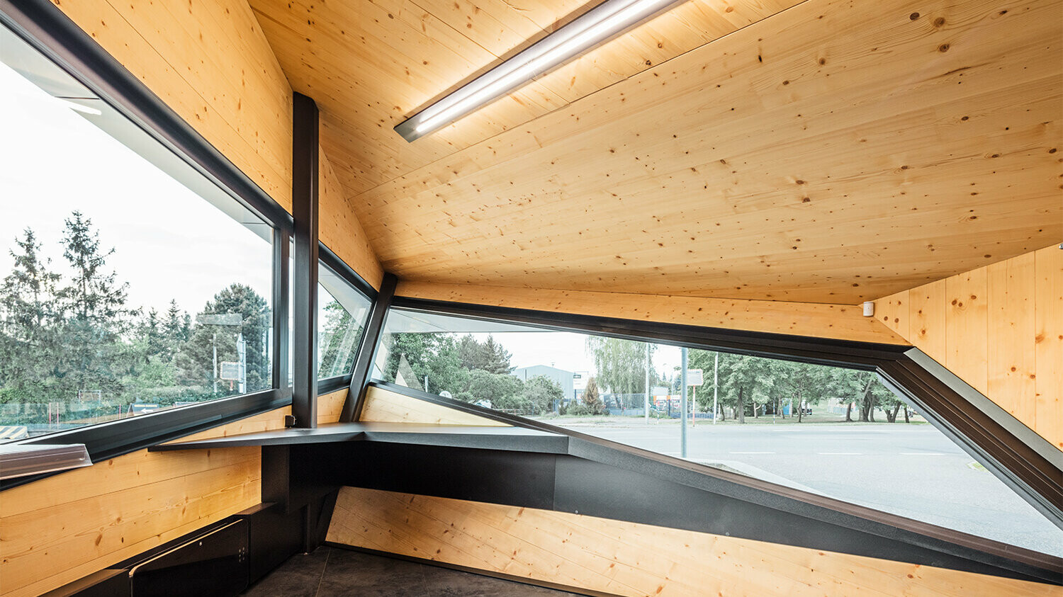 Interior view of the petrol station with wooden cladding, the windows enable a far-reaching view of what is happening on site.