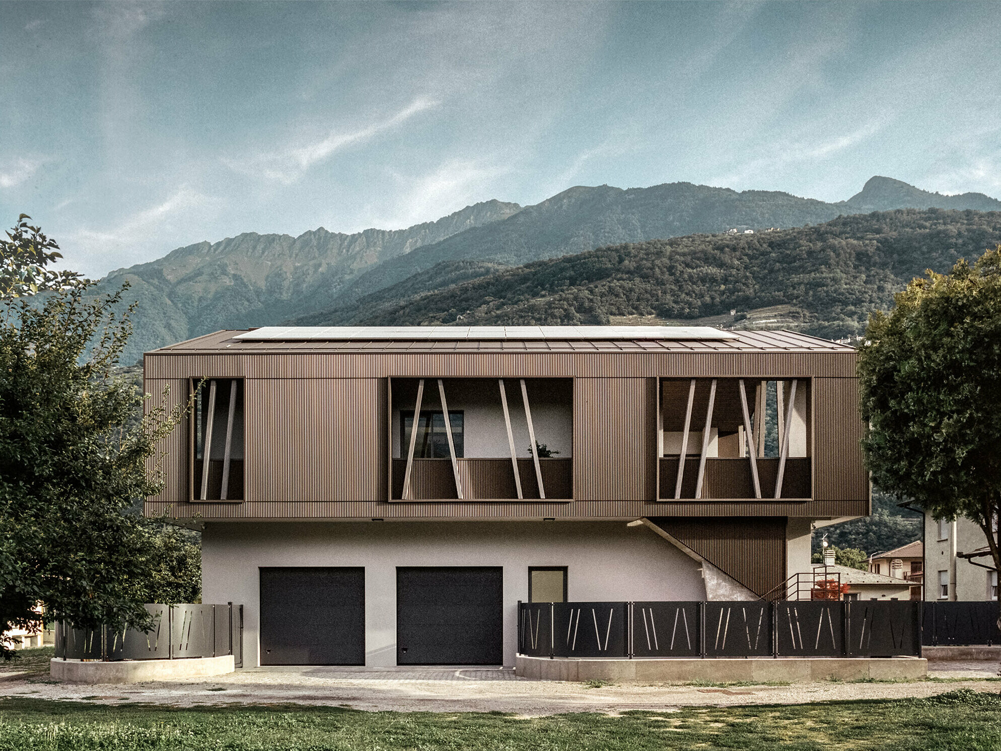 The house after the reconstruction work: The plaster façade has a fresh look, the upper storey, which is clad with the serrated profile and Prefalz, received an open and contemporary appearance with a new design language and the wooded mountain landscape stretches out in the background.