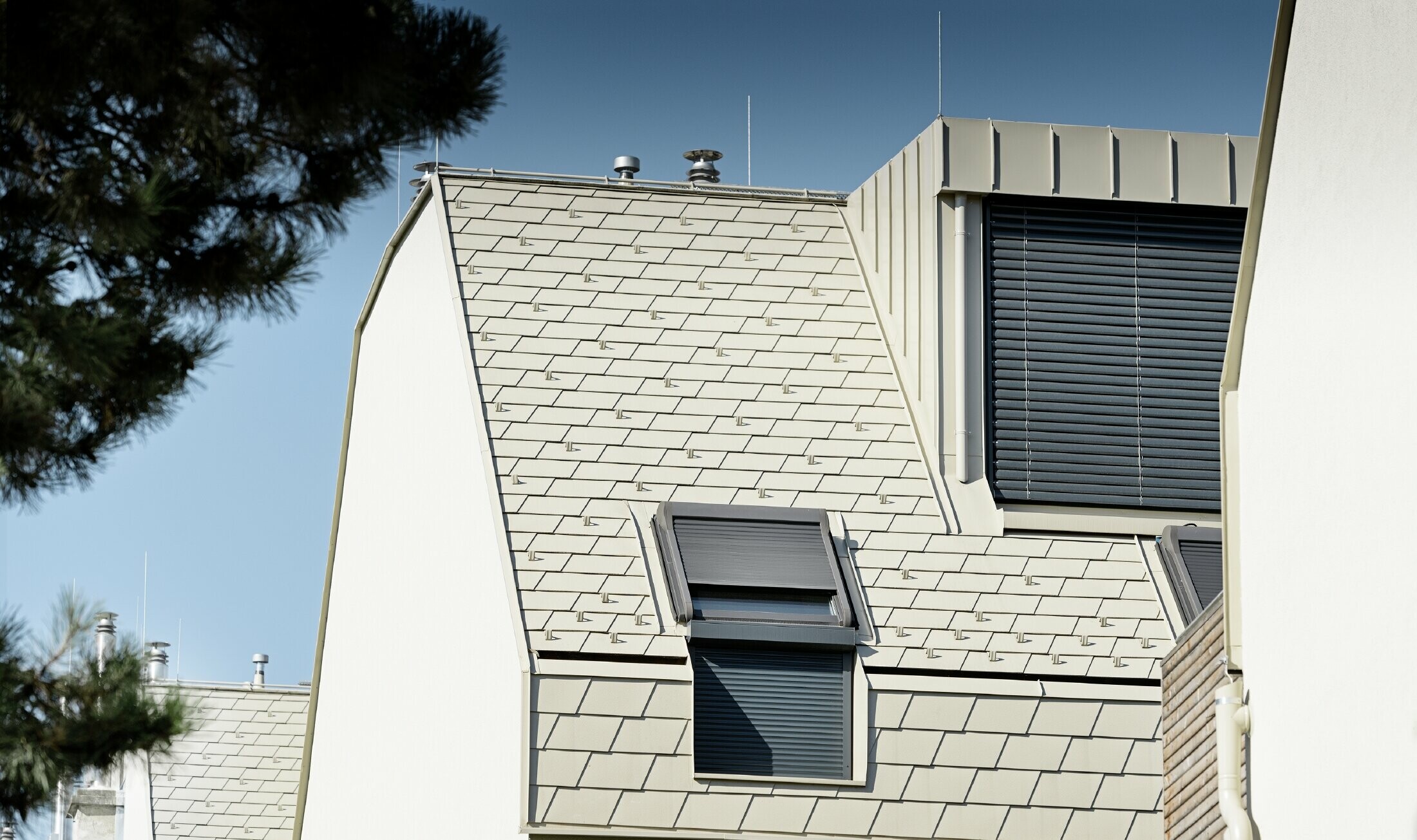 New residential complex with a large aluminium roof surface and a host of roof windows