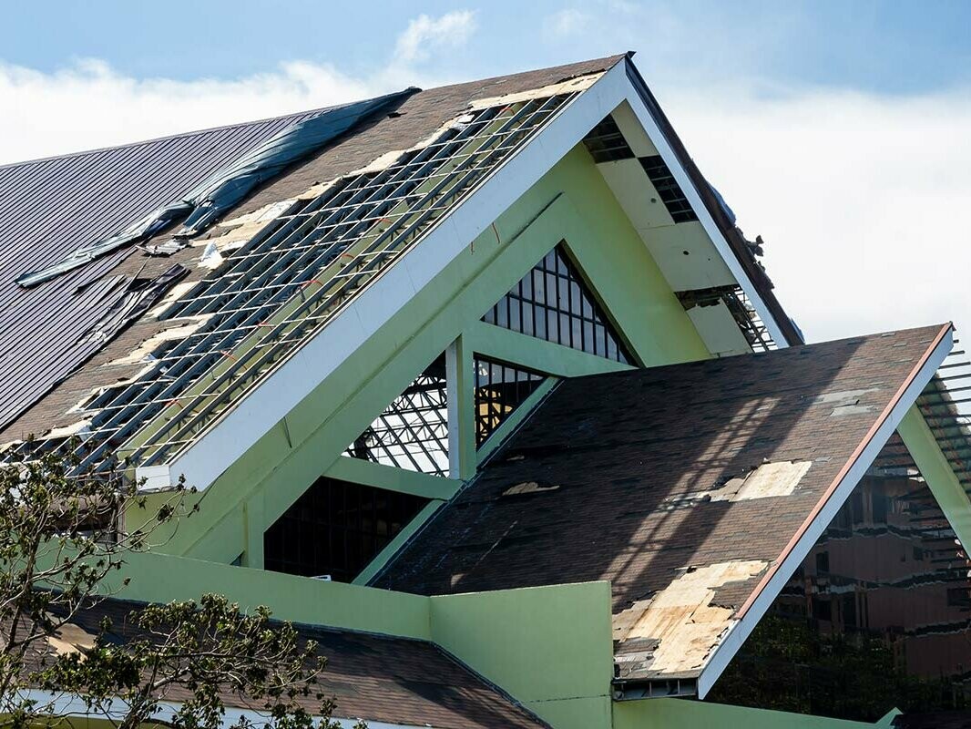 Heavily damaged, partially ripped off roof after heavy storms