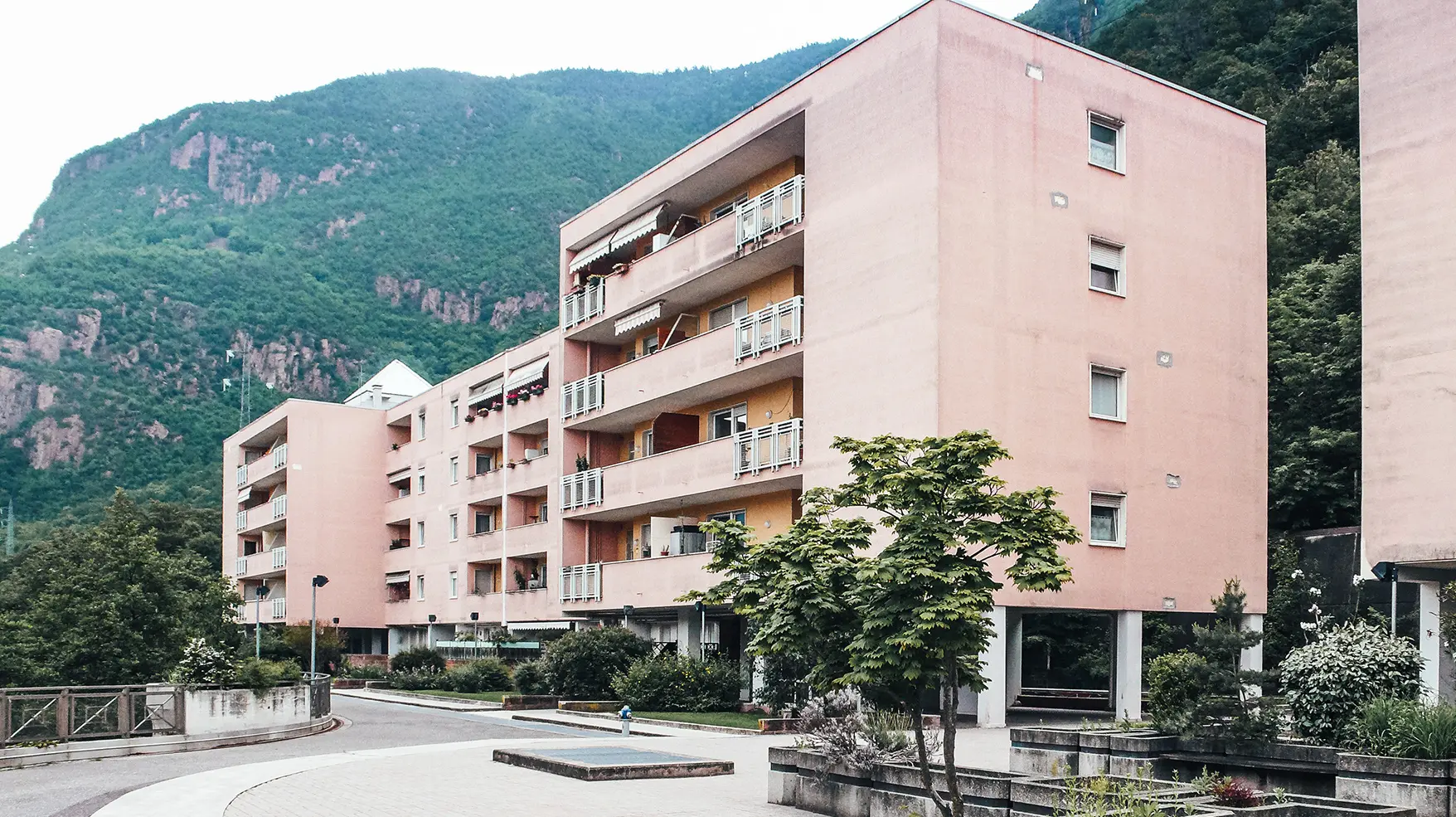 Before photo of the project on Köstenweg: a salmon-coloured, outdated concrete building.