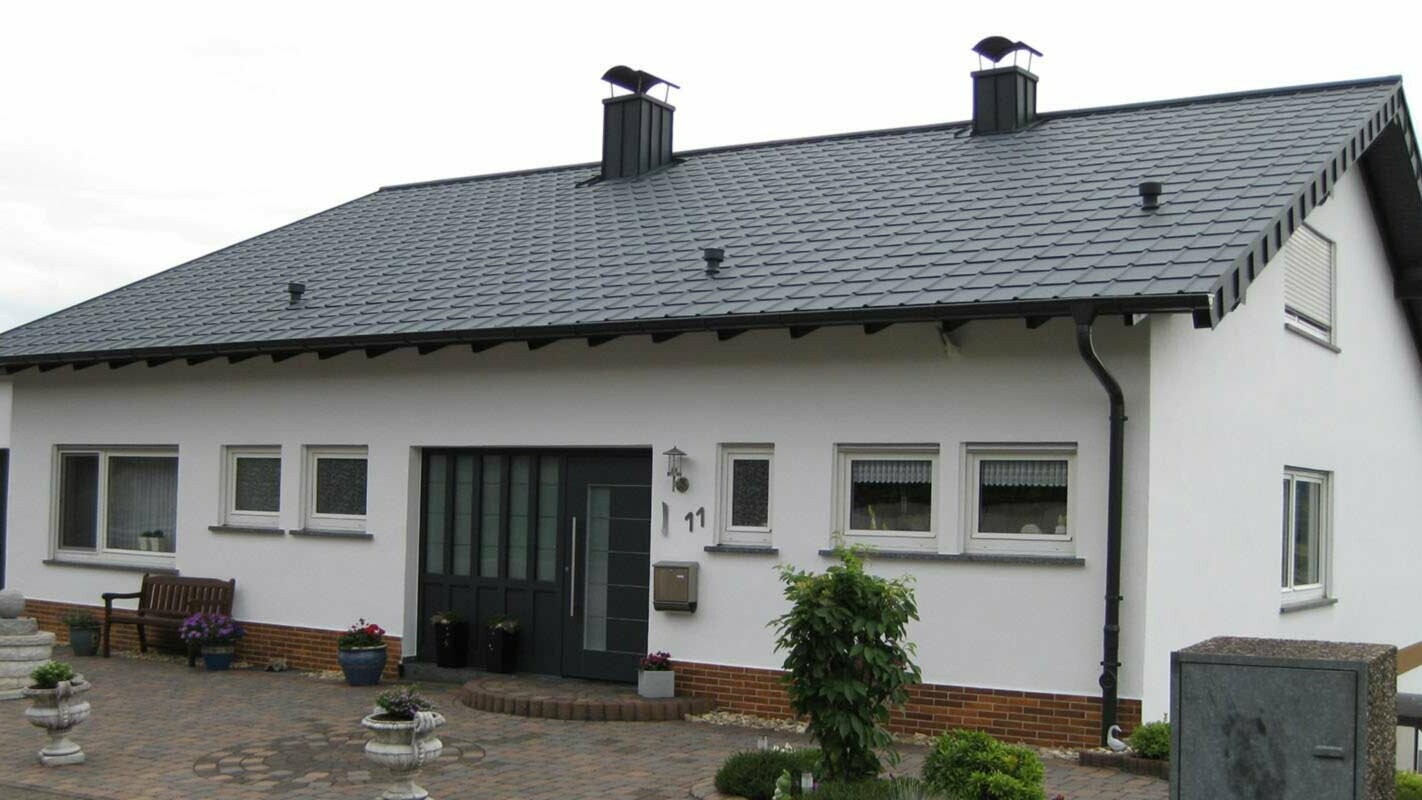 Detached house with a gable roof after roof renovation with PREFA roof tiles