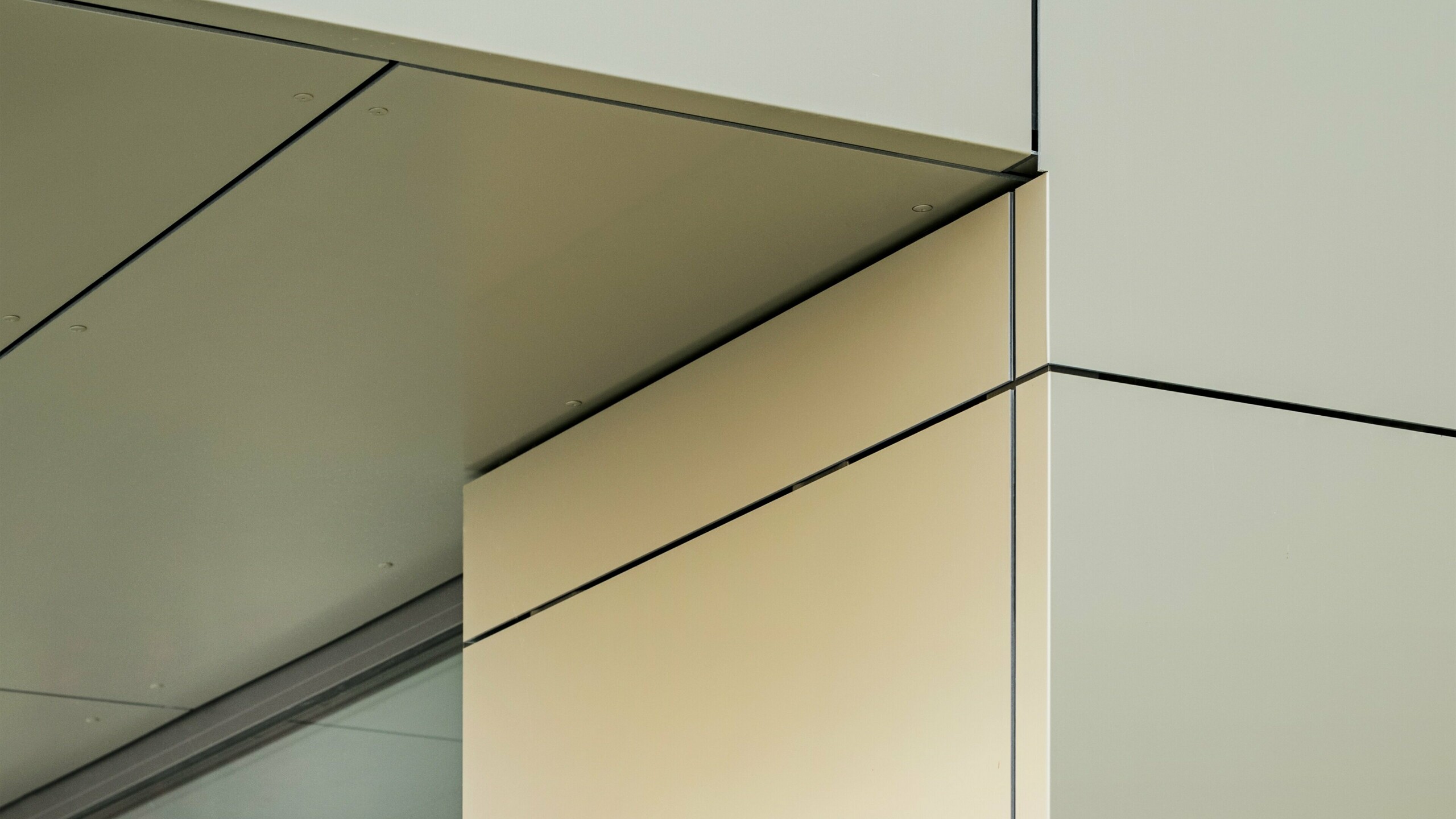 Close-up of the façade of the town hall in Alzenau, showing the precise edges and transitions of the PREFA aluminium composite panels in bronze colour. The panels are perfectly joined together, creating clean, modern lines. The metallic sheen of the panels is emphasised by the fine joint lines and minimalist details of the architecture, giving the façade an elegant and contemporary look.