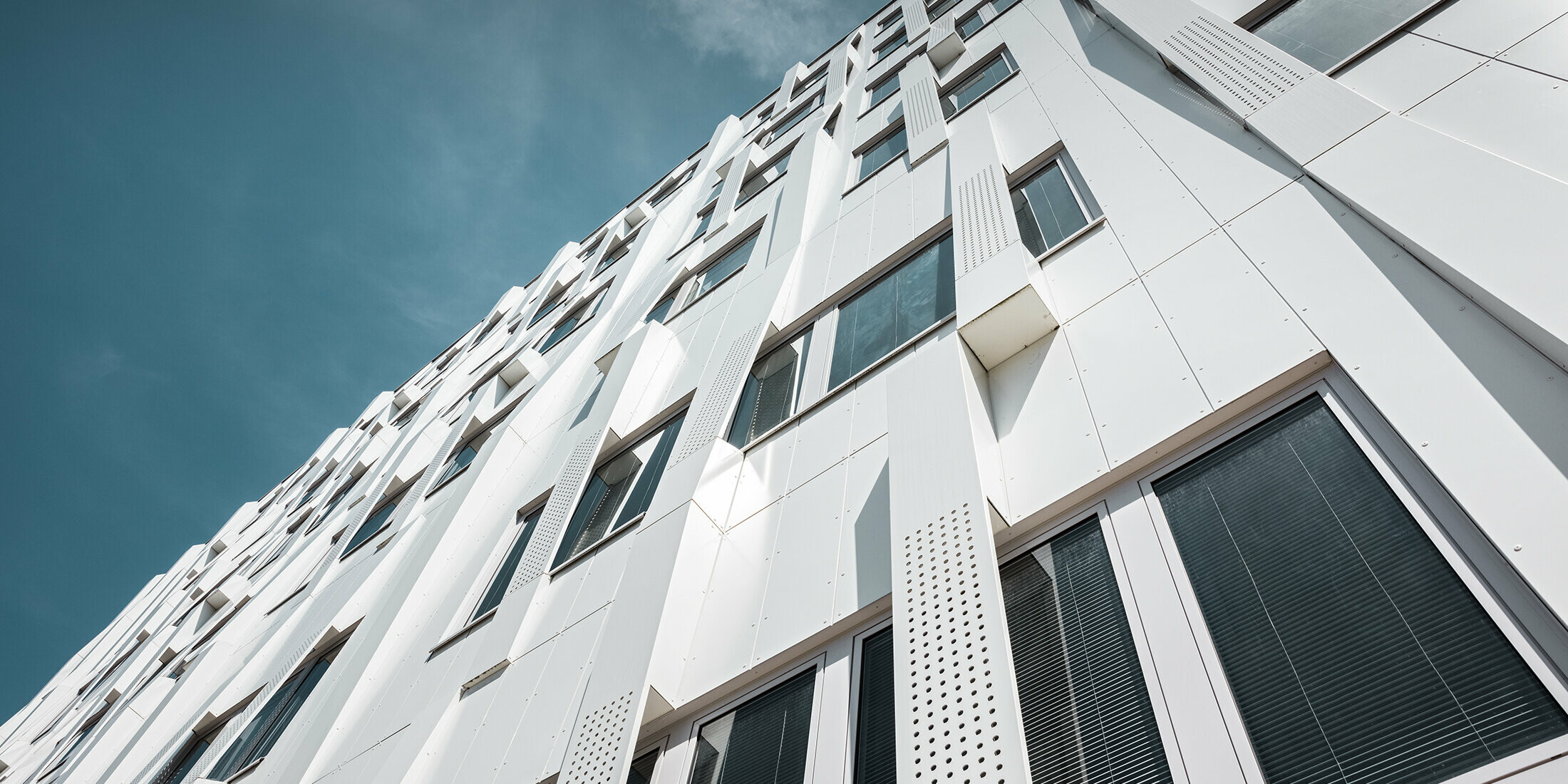 Special 3D façade, with perforated aluminium composite panel cassettes and normal PREFA composite panels in pure white, PREFA cassette façade