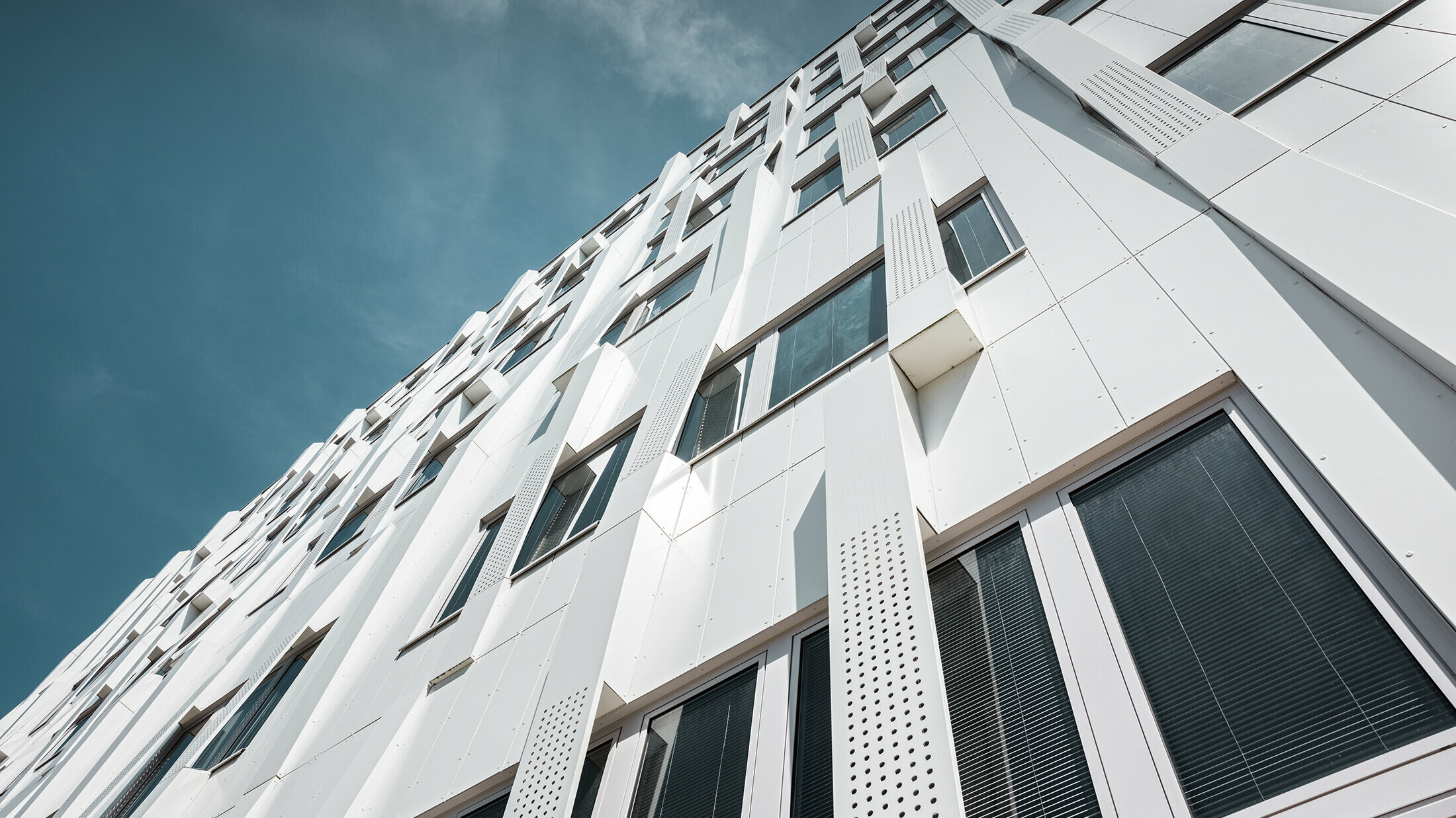 Special 3D façade, with perforated aluminium composite panel cassettes and normal PREFA composite panels in pure white, PREFA cassette façade