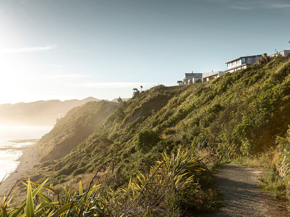 Shot of the landscape of Motunau, showing Motunau Beach, the vegetation as well as the cliffs. A few houses were built close to the edge of these cliffs, among them the Whitecaps House by Three Sixty Architecture.