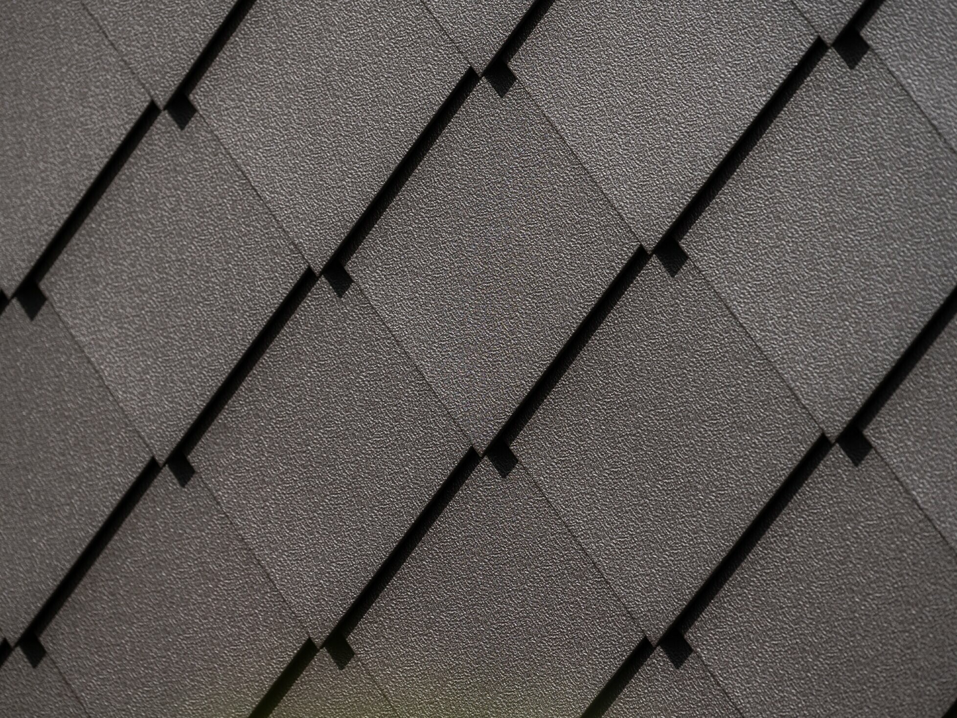 Close-up of PREFA rhomboid façade tile 29 × 29 in nut brown with stucco finish