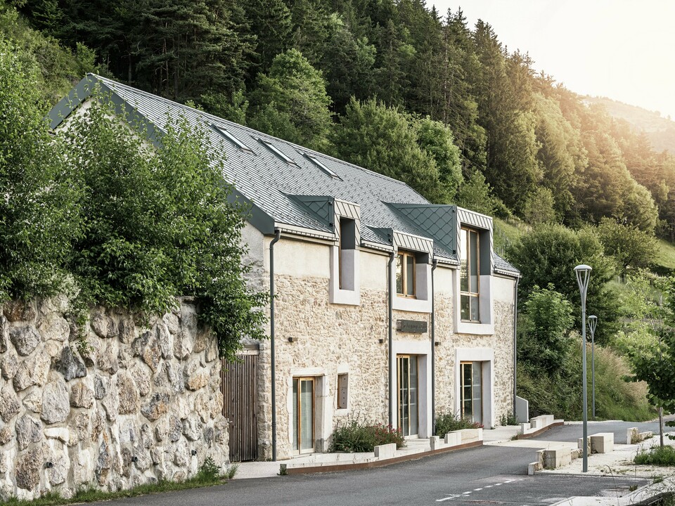 The restored barn ‘La Grange à Gaby’ in Engins, France. The building combines traditional stone masonry with a modern PREFA aluminium roof made of 29 × 29 cm rhomboid panels. The renovation combines historical construction with contemporary architecture and sustainable materials.