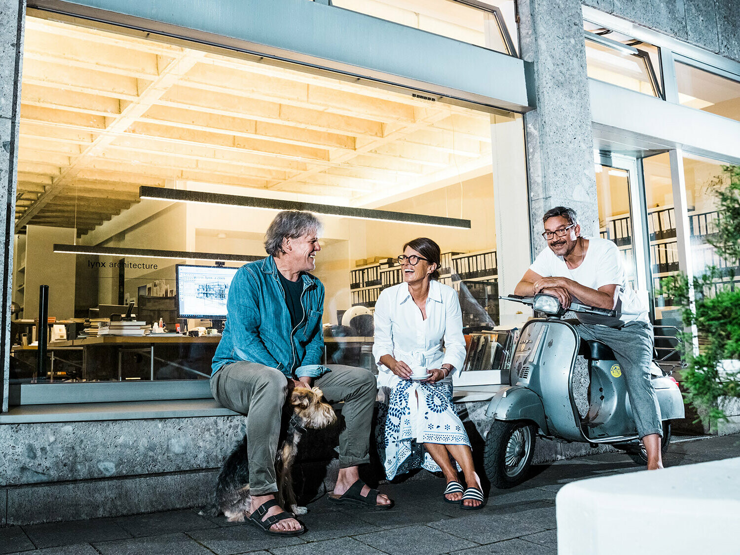Portrait of the architects Volker Petereit, Susanne Muhr and Dirk Härle with their dog Emma in front of their office in Munich.