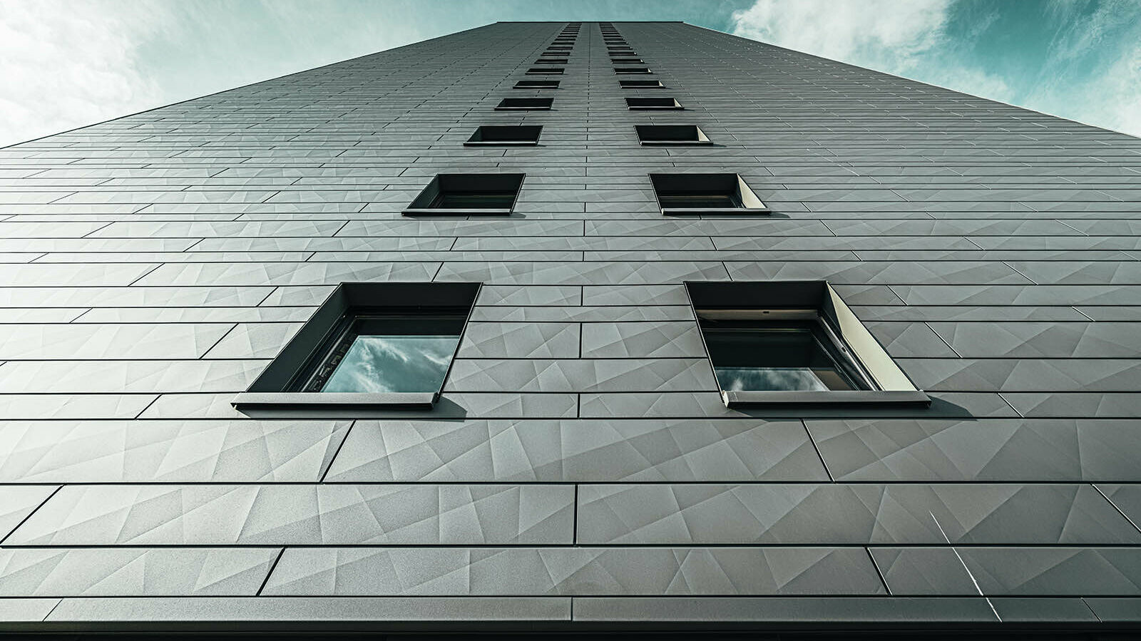 PREFA façade sidings on the Erfstadt high-rise building with a beautiful contrast to the blue sky in the background of the picture.