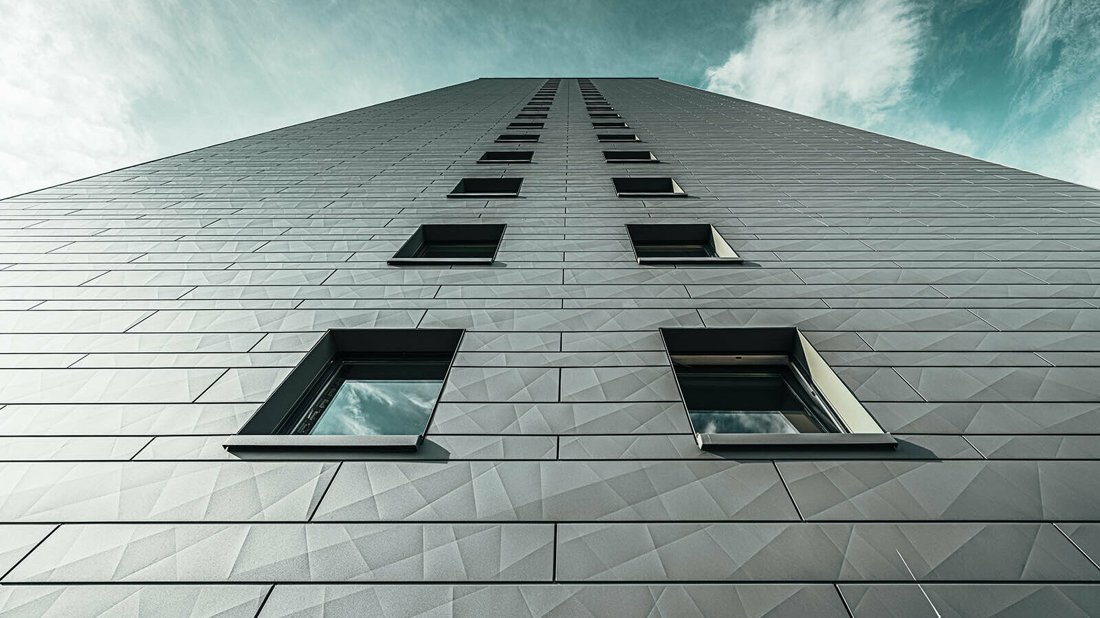 PREFA façade sidings on the Erfstadt high-rise building with a beautiful contrast to the blue sky in the background of the picture.